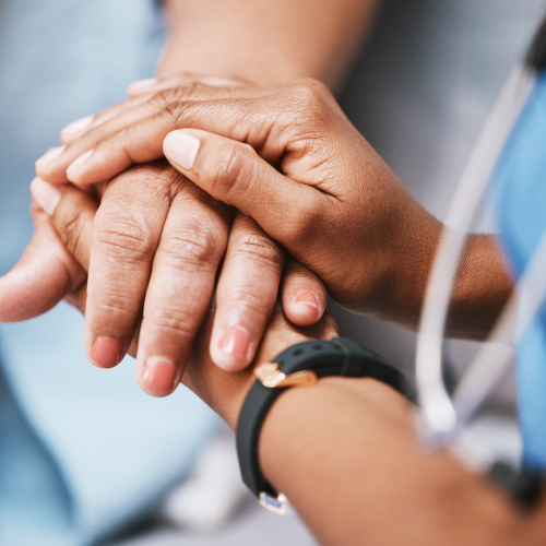 A close-up of medical professionals holding hands, symbolizing support, empathy, and mental health care for those in the healthcare industry. The image represents resilience, connection, and emotional well-being.